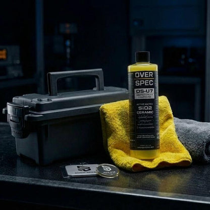 Over Spec car care product with a yellow towel and toolbox on a dark surface